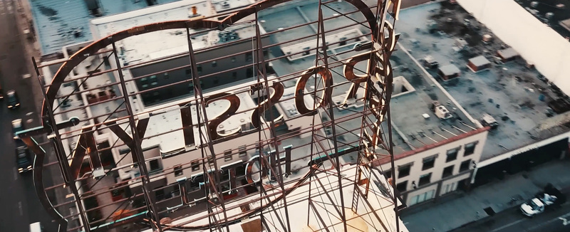 Aerial view of the historic Rosslyn Hotel sign structure overlooking the urban streets of Los Angeles California United States.