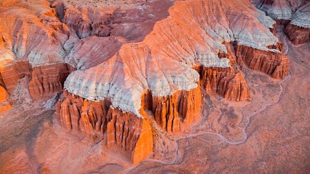 Aerial view of the striking red rock badlands with layered sandstone formations deep canyons and rugged terrain in Hanksville Utah United States.