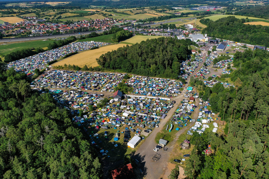 Aerial view of the Eventzentrum Strohofer Geiselwind musichall campsite with tents and cars surrounded by forests and fields in Geiselwind Bayern Germany. Aerial view of the Eventzentrum Strohofer Geiselwind musichall campsite with tents and cars surrounded by forests and fields in Geiselwind Bayern Germany.