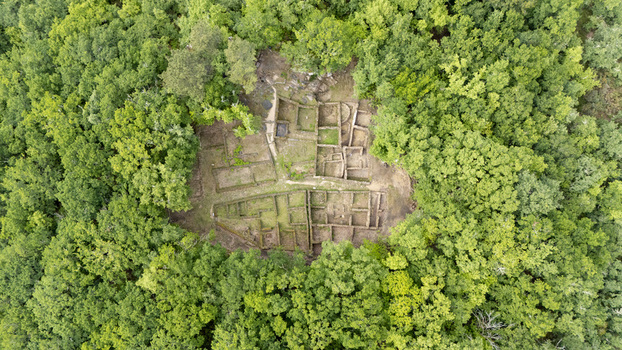 Aerial view of the stone foundations and ancient ruins of Castro de Armea surrounded by dense green forest in Allariz Province of Ourense Spain. Aerial view of the stone foundations and ancient ruins of Castro de Armea surrounded by dense green forest in Allariz Province of Ourense Spain.