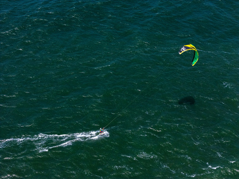 Aerial view of a kitesurfer gliding across the deep blue water at Depok Beach Special Region of Yogyakarta Indonesia.