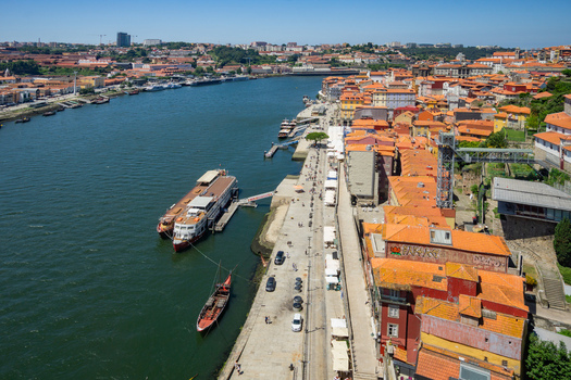 Aerial view of terracotta rooftops cascading down to the Douro River where boats bob gently creating a tapestry of warm hues against the cool water Porto Porto District Portugal. Aerial view of terracotta rooftops cascading down to the Douro River where boats bob gently creating a tapestry of warm hues against the cool water Porto Porto District Portugal.