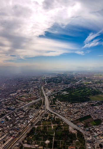 Aerial view of the historic Bala Hisar Fort surrounded by the sprawling urban landscape highway intersections and green spaces in Peshawar Khyber Pakhtunkhwa Pakistan.