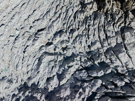 Aerial view of a glacier with deep crevasses and ice formations in Nepal.