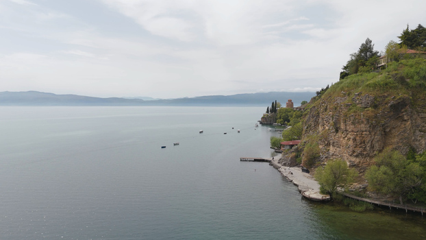 Aerial view of the Church of St. John at Kaneo perched on a cliff overlooking Lake Ohrid with small boats on the water and lush greenery in Ohrid Municipality of Ohrid North Macedonia. Aerial view of the Church of St. John at Kaneo perched on a cliff overlooking Lake Ohrid with small boats on the water and lush greenery in Ohrid Municipality of Ohrid North Macedonia.