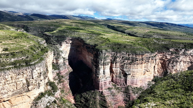 Aerial view of El Vergel canyon with deep rocky walls lush green vegetation on the plateau and dramatic shadows under a cloudy sky in Torotoro Potosi Department Bolivia. Aerial view of El Vergel canyon with deep rocky walls lush green vegetation on the plateau and dramatic shadows under a cloudy sky in Torotoro Potosi Department Bolivia.