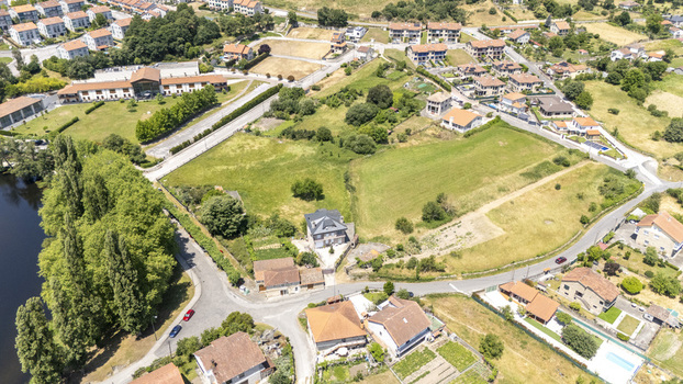 Aerial view of residential houses green fields a riverbank with trees and winding roads in Allariz Province of Ourense Spain. Aerial view of residential houses green fields a riverbank with trees and winding roads in Allariz Province of Ourense Spain.