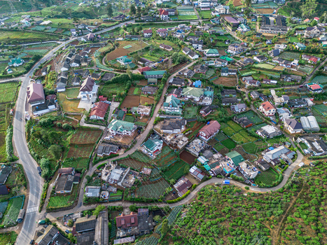 Aerial view of the town of Nuwara Eliya nestled among lush green tea plantations winding roads and residential buildings in Nuwara Eliya Central Province Sri Lanka. Aerial view of the town of Nuwara Eliya nestled among lush green tea plantations winding roads and residential buildings in Nuwara Eliya Central Province Sri Lanka.