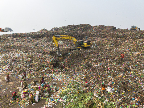 Aminbazar Bangladesh 26 January 2025 Aerial view of the Aminbazar landfill with yellow excavators moving waste and many people scavenging through piles of garbage under a hazy sky. Aminbazar Bangladesh 26 January 2025 Aerial view of the Aminbazar landfill with yellow excavators moving waste and many people scavenging through piles of garbage under a hazy sky.