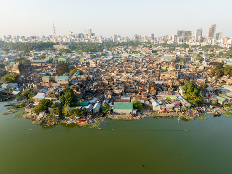 Aerial view of dense settlements contrasting with modern skyline and green waters a juxtaposition of urban realities Dhaka Dhaka Division Bangladesh. Aerial view of dense settlements contrasting with modern skyline and green waters a juxtaposition of urban realities Dhaka Dhaka Division Bangladesh.