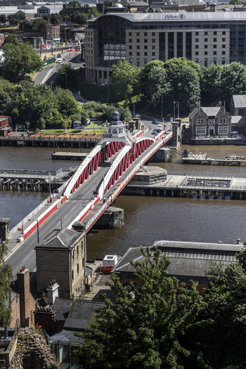 Aerial view of the historic red Swing Bridge spanning the River Tyne with the Hilton hotel in the background in Newcastle upon Tyne England United Kingdom. Aerial view of the historic red Swing Bridge spanning the River Tyne with the Hilton hotel in the background in Newcastle upon Tyne England United Kingdom.