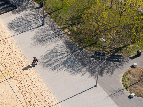 Vilnius Lithuania 20 April 2026 Aerial view of a skateboarder on a sandy slope next to a path in Chiune Sugihara Sakura Park with trees casting long shadows. Vilnius Lithuania 20 April 2026 Aerial view of a skateboarder on a sandy slope next to a path in Chiune Sugihara Sakura Park with trees casting long shadows.