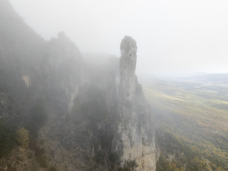 Aerial view of the rocky peaks of the Pyrenees mountains shrouded in thick mist with forested slopes below in Spain. Aerial view of the rocky peaks of the Pyrenees mountains shrouded in thick mist with forested slopes below in Spain.