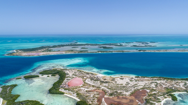 Aerial view of Los Roques archipelago featuring turquoise waters coral reefs sandy islands and salt pans under a clear blue sky in Los Roques Dependencias Federale Venezuela. Aerial view of Los Roques archipelago featuring turquoise waters coral reefs sandy islands and salt pans under a clear blue sky in Los Roques Dependencias Federale Venezuela.