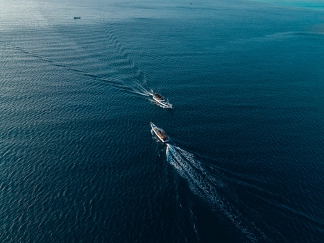 Aerial view of two traditional wooden boats navigating the deep blue waters of the Java Sea near Karimunjawa Jawa Tengah Indonesia. Aerial view of two traditional wooden boats navigating the deep blue waters of the Java Sea near Karimunjawa Jawa Tengah Indonesia.