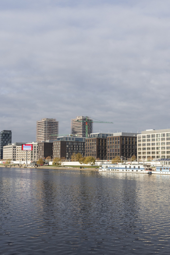 View of modern office buildings and residential towers along the Spree river with boats docked at the waterfront under a cloudy sky Berlin Berlin Germany. View of modern office buildings and residential towers along the Spree river with boats docked at the waterfront under a cloudy sky Berlin Berlin Germany.