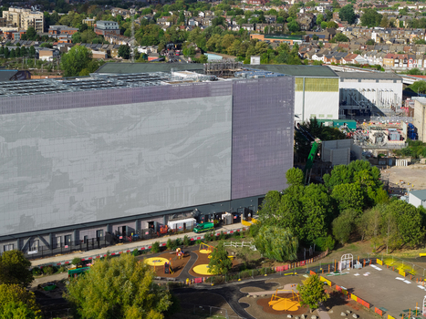 Aerial view of a large modern data center building with a metallic facade situated near a residential area and a playground in the United Kingdom. Aerial view of a large modern data center building with a metallic facade situated near a residential area and a playground in the United Kingdom.