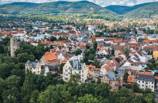 Aerial view of the historic town with its dense collection of red tiled rooftops lush green trees and surrounding rolling hills in Saalfeld Thuringia Germany. Aerial view of the historic town with its dense collection of red tiled rooftops lush green trees and surrounding rolling hills in Saalfeld Thuringia Germany.