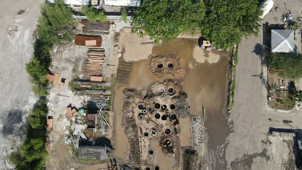 Aerial view of a construction site featuring circular excavation pits piles of construction materials and workers in an industrial area in Cilegon Banten Indonesia. Aerial view of a construction site featuring circular excavation pits piles of construction materials and workers in an industrial area in Cilegon Banten Indonesia.