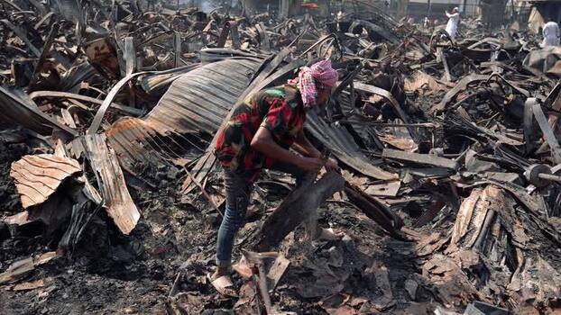 View of a man searching through charred debris after a fire Bangladesh. View of a man searching through charred debris after a fire Bangladesh.