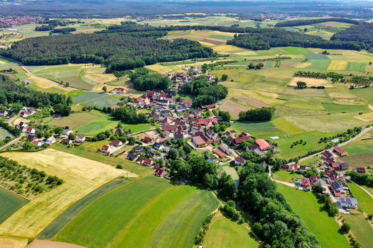 Aerial view of the village houses and surrounding agricultural landscape with green fields and forests in Neunkirchen am Brand Bavaria Germany. Aerial view of the village houses and surrounding agricultural landscape with green fields and forests in Neunkirchen am Brand Bavaria Germany.