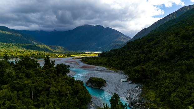 Aerial view of the Hokitika Gorge with its stunning turquoise waters cutting through the rugged landscape framed by dense forest and dramatic sky Hokitika Gorge West Coast Region New Zealand. Aerial view of the Hokitika Gorge with its stunning turquoise waters cutting through the rugged landscape framed by dense forest and dramatic sky Hokitika Gorge West Coast Region New Zealand.