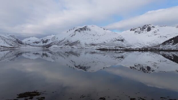 Aerial view of Lofoten mountains reflected in calm water Norway.