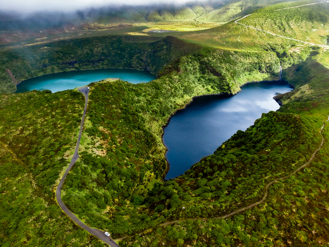 Aerial view of twin lakes nestled amidst verdant hills where turquoise waters meet deep blue hues creating a stunning contrast in this natural paradise Flores Azores Portugal.