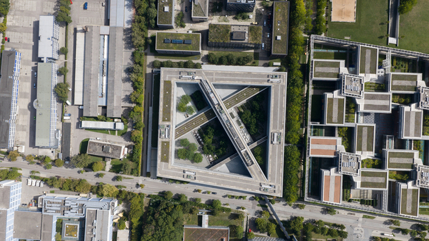 Unterfohring Germany 12 September 2026 Aerial view of Allianz Commercial headquarters featuring a distinct triangular building design with green courtyards and surrounding office structures.