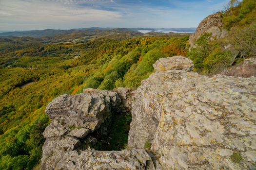 Aerial view of the rocky summit of Sitno in Stiavnicke Vrchy surrounded by vibrant autumn forests and rolling hills in Ilija Banska Bystrica Regio Slovakia.