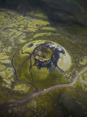 Aerial view of a striking volcanic crater adorned with vibrant green moss contrasting sharply with the dark interior Highlands Iceland.