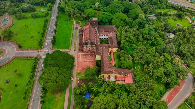 Aerial view of the Church of St. Francis of Assisi surrounded by lush green trees manicured lawns and historic grounds in Old Goa Goa India. Aerial view of the Church of St. Francis of Assisi surrounded by lush green trees manicured lawns and historic grounds in Old Goa Goa India.