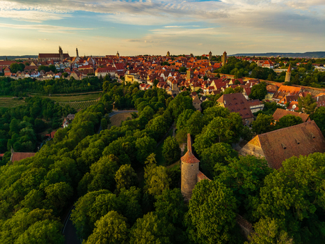 Aerial view of the historic town of Rothenburg ob der Tauber with medieval red tiled rooftops and defensive walls surrounded by lush greenery in Rothenburg ob der Tauber Bavaria Germany. Aerial view of the historic town of Rothenburg ob der Tauber with medieval red tiled rooftops and defensive walls surrounded by lush greenery in Rothenburg ob der Tauber Bavaria Germany.