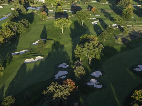 Aerial view of a golf course in autumn with lush green fairways sand bunkers and trees showing fall foliage in Glenview Illinois United States. Aerial view of a golf course in autumn with lush green fairways sand bunkers and trees showing fall foliage in Glenview Illinois United States.