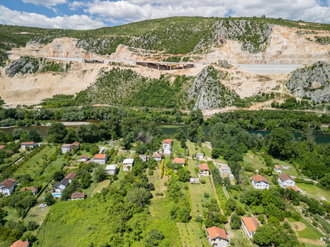 Aerial view of Pocitelj Bridge spanning the rocky landscape above the river with lush green vegetation and scattered houses in Pocitelj Federation of Bosnia Bosnia and Herzegovina. Aerial view of Pocitelj Bridge spanning the rocky landscape above the river with lush green vegetation and scattered houses in Pocitelj Federation of Bosnia Bosnia and Herzegovina.
