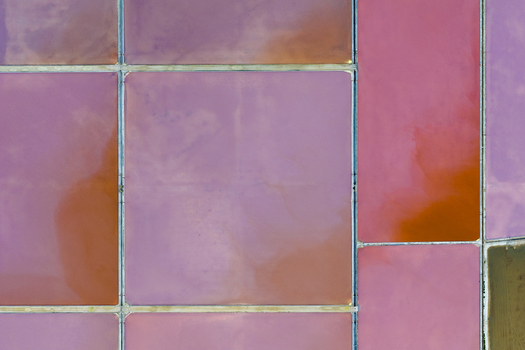 Aerial view of vibrant pink and orange hues blend across the geometric salt ponds creating a stunning mosaic from above San Pedro del Pinatar Region of Murcia Spain. Aerial view of vibrant pink and orange hues blend across the geometric salt ponds creating a stunning mosaic from above San Pedro del Pinatar Region of Murcia Spain.