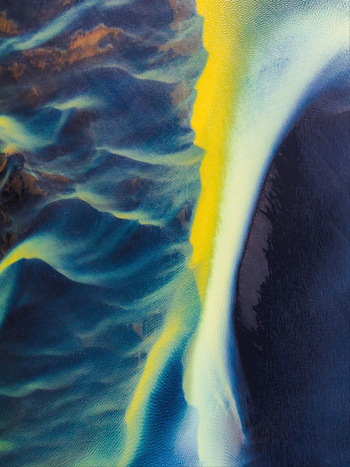 Aerial view of vibrant glacial river patterns with striking blue and yellow sediment flowing through dark volcanic terrain in Iceland. Aerial view of vibrant glacial river patterns with striking blue and yellow sediment flowing through dark volcanic terrain in Iceland.