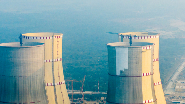 Aerial view of the Rooppur Nuclear Power Plant cooling towers with construction cranes and industrial infrastructure in Pabna Rajshahi Division Bangladesh.