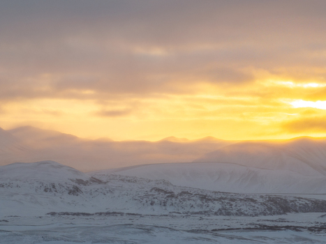 Aerial view of Hverfjall volcanic crater covered in snow during a golden sunset with soft light illuminating the rugged landscape Thingeyjarsveit Iceland. Aerial view of Hverfjall volcanic crater covered in snow during a golden sunset with soft light illuminating the rugged landscape Thingeyjarsveit Iceland.
