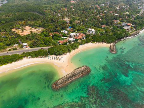 Aerial view of Devil s Rock breakwater sandy beaches and turquoise waters of the tropical coastline in Ahangama Southern Province Sri Lanka. Aerial view of Devil s Rock breakwater sandy beaches and turquoise waters of the tropical coastline in Ahangama Southern Province Sri Lanka.