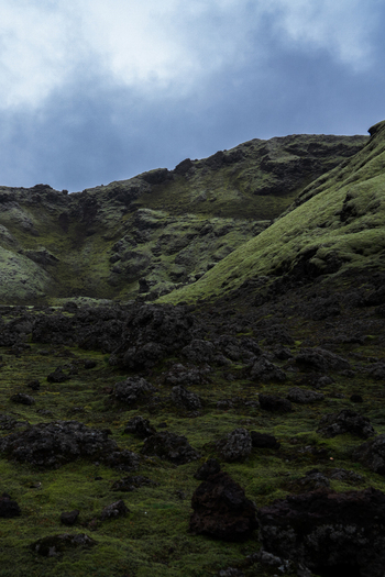 View of emerald hills meet dark rugged lava fields under a moody sky creating a dramatic landscape Skaftárhreppur Skaftárhreppur Iceland. View of emerald hills meet dark rugged lava fields under a moody sky creating a dramatic landscape Skaftárhreppur Skaftárhreppur Iceland.