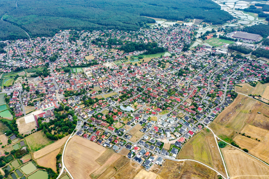 Aerial view of the town of Rottenbach with its red roofed houses nestled between lush green forests and agricultural fields in Rottenbach Bavaria Germany. Aerial view of the town of Rottenbach with its red roofed houses nestled between lush green forests and agricultural fields in Rottenbach Bavaria Germany.