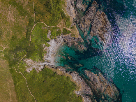 Aerial view of Lansallos beach featuring rugged cliffs turquoise waters and a winding coastal path in Lansallos England United Kingdom. Aerial view of Lansallos beach featuring rugged cliffs turquoise waters and a winding coastal path in Lansallos England United Kingdom.