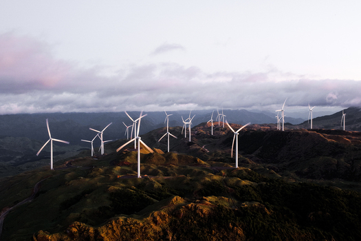 Aerial view of Harapaki Wind Farm with wind turbines on rolling green hills under a cloudy sky in Te Haroto Hawke s Bay Region New Zealand.