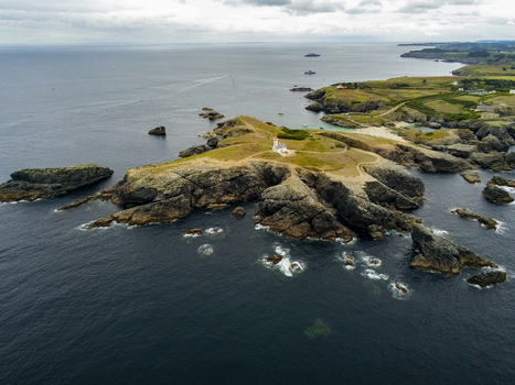Aerial view of the Pointe des Poulains lighthouse situated on a rugged rocky peninsula surrounded by the Atlantic Ocean in Sauzon Bretagne France. Aerial view of the Pointe des Poulains lighthouse situated on a rugged rocky peninsula surrounded by the Atlantic Ocean in Sauzon Bretagne France.