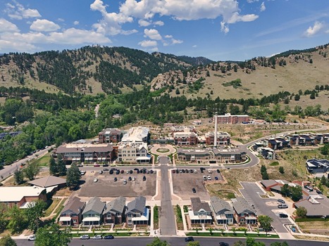 Aerial view of a residential neighborhood with modern houses parking lots and green trees nestled against the foothills of the Rocky Mountains in Boulder Colorado United States. Aerial view of a residential neighborhood with modern houses parking lots and green trees nestled against the foothills of the Rocky Mountains in Boulder Colorado United States.