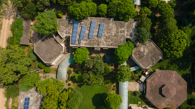 Lahore Punjab Pakistan 08 September 2026 Aerial view of the government office building data canter featuring rooftop solar panels surrounded by lush green trees.