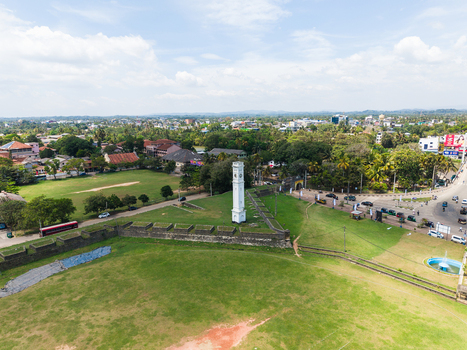 Aerial view of the historic Matara Clock Tower and stone ramparts of the fort surrounded by lush greenery and urban landscape in Matara Southern Province Sri Lanka. Aerial view of the historic Matara Clock Tower and stone ramparts of the fort surrounded by lush greenery and urban landscape in Matara Southern Province Sri Lanka.