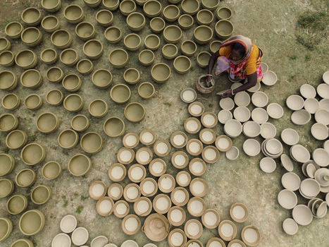 Joypurhat Bangladesh 28 September 2026 Aerial view of a woman working as a potter shaping clay bowls arranged in rows on the ground in a rural workshop. Joypurhat Bangladesh 28 September 2026 Aerial view of a woman working as a potter shaping clay bowls arranged in rows on the ground in a rural workshop.