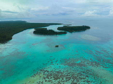 Aerial view of the turquoise waters around the isles creates a stunning contrast with the green forest Pine Island L Île des Pins New Caledonia. Aerial view of the turquoise waters around the isles creates a stunning contrast with the green forest Pine Island L Île des Pins New Caledonia.